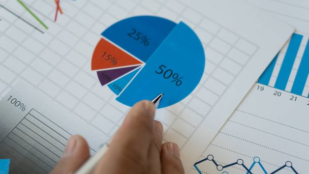Az üzletemberek grafikonokat, pénzügyi grafikonokat elemeznek, amelyek eredményeket mutatnak, és stratégiákat számítanak ki a sikeres folyamat megtervezéséhez. - Fotó, kép