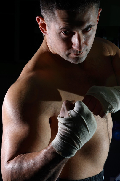 Le jeune sportif est engagé dans la boxe et pose dans une salle devant une poire
 - Photo, image