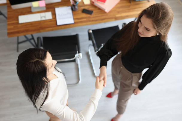 Handshake of two business women in office top view - Photo, Image