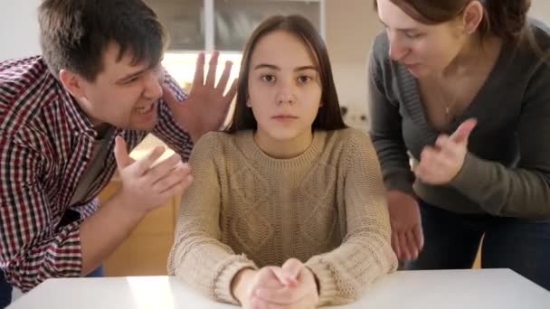 Anne ve baba mutfakta masanın arkasında oturan genç kıza bağırıyor ve çığlık atıyorlar. Aile içi şiddet, çatışmalar ve ilişki sorunları - Video, Çekim