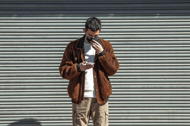 portrait de jeune homme dans la rue avec téléphone portable - Photo, image