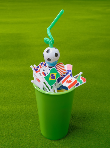 Beber palha em copo verde com muitas bandeira da nação
 - Foto, Imagem