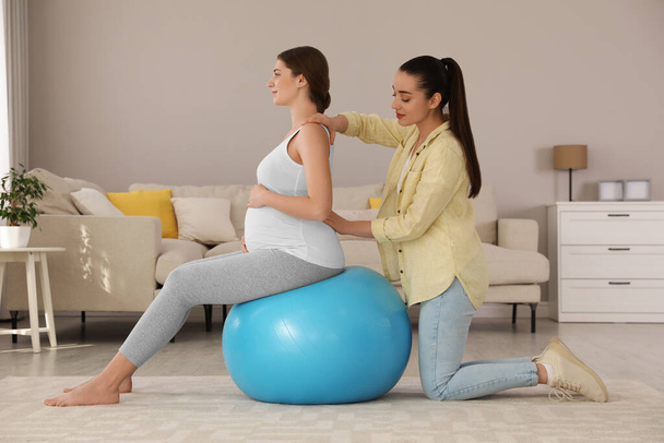 Doula working with pregnant woman in living room. Preparation for child birth - Photo, Image