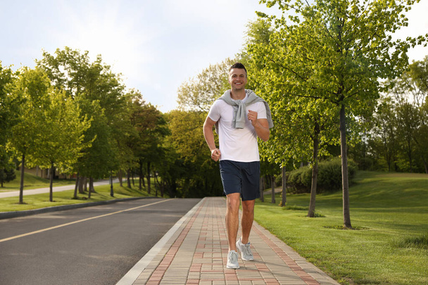 Young man in fitness clothes running outdoors - Foto, Bild