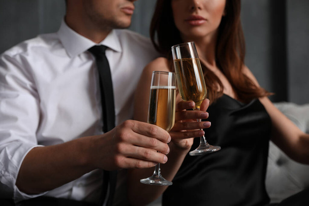 Beautiful couple with glasses of champagne indoors, closeup. Luxury lifestyle - Fotó, kép