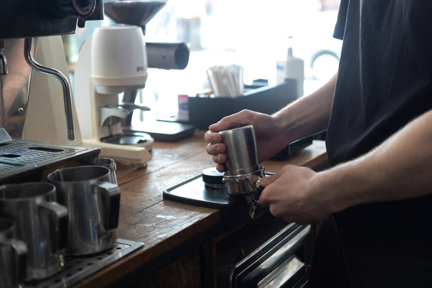 Barista gezichtsloos maken koffie latte kunst met espresso machine in cafe  - Foto, afbeelding