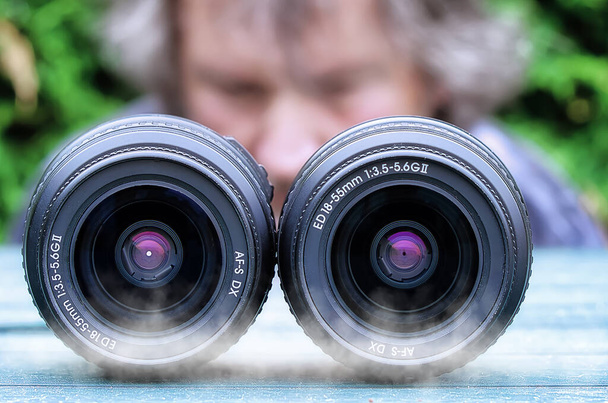 Two photo lenses on a table in front of a photographer - Φωτογραφία, εικόνα