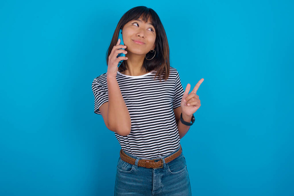 mladá žena drží moderní mobilní telefon a dělá video volání vlny palmy v gestu ahoj. Lidé moderní technologie koncept - Fotografie, Obrázek
