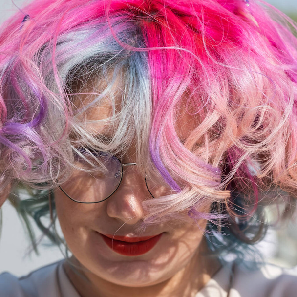 Close-up portrait of curly Caucasian woman with multi-colored hair wearing glasses. Model for hairstyles - Valokuva, kuva