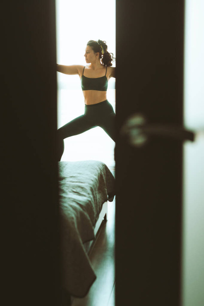 жінка робить йогу вдома біля великого вікна здоровий спосіб життя
 - Фото, зображення