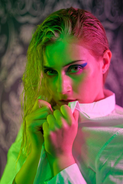 beautiful blonde italian girl posing in photo studio with colorful lights. High quality photo - 写真・画像