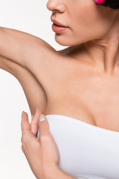 partial view of young woman touching smooth armpit with hand isolated on white - Photo, Image