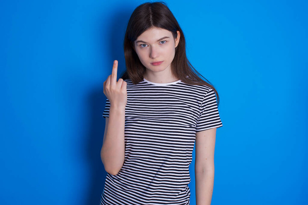 junge Frau zeigt Mittelfinger schlechtes Zeichen bittet nicht zu belästigen. Provokation und unhöfliche Haltung. - Foto, Bild