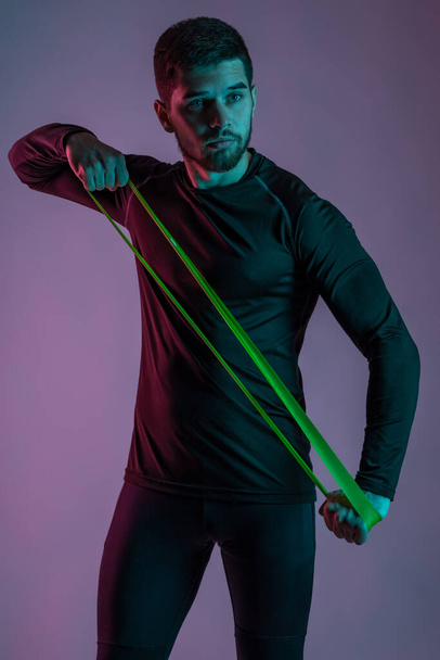 Sporty young man working out with resistance loop band - Foto, Imagem