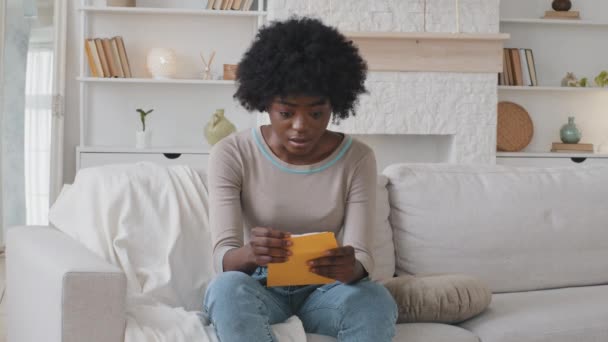 Upset African American ethnic girl feel frustrated open envelope at home reading bad news receive paper post mail letter about financial problem, bank debt bill, failed exam test results or subpoena - Video
