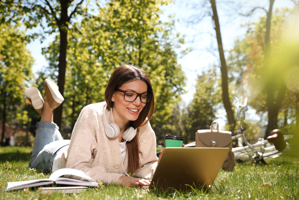 Beautiful woman working with laptop in park - Foto, imagen