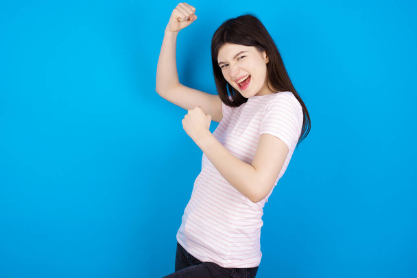 Profile photo of excited young brunette woman raising fists celebrating black Friday shopping - Photo, Image