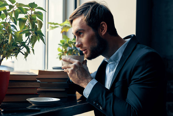 uomo d'affari in un caffè vestito bere caffè riposo colazione - Foto, immagini