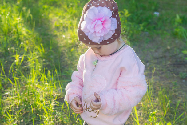 A wild field butterfly sits on a pink jacket baby girl. - Φωτογραφία, εικόνα