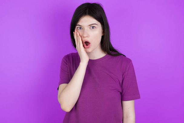 Shocked young brunette woman looks with great surprisment being very stunned, astonished with unexpected news, Facial expressions concept. - 写真・画像