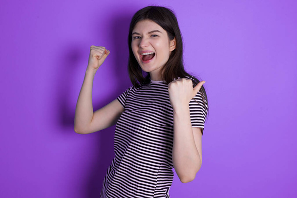 Hooray cool young brunette woman point back empty space hand fist - Photo, Image