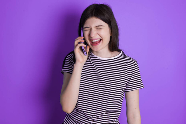 Overemotive szczęśliwy młoda brunetka kobieta śmieje się pozytywnie słyszy zabawną historię od przyjaciela podczas rozmowy telefonicznej - Zdjęcie, obraz