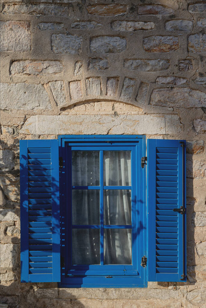 A gray building with blue window frames in the Greek style. Travel and architecture concept - Foto, Imagem