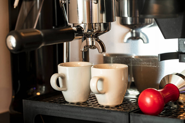 Close up image of professional espresso machine pouring in two cups - 写真・画像