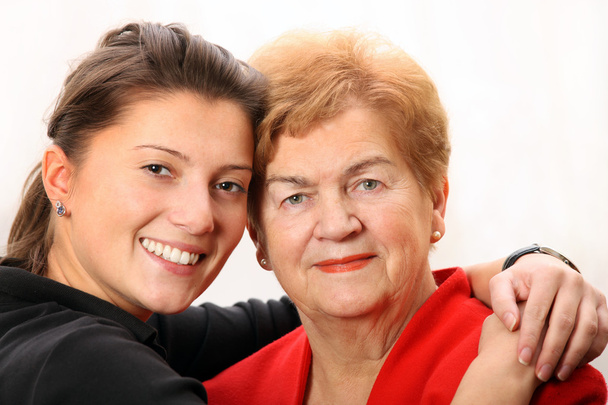 Um retrato de uma neta posando com sua avó sobre fundo branco
 - Foto, Imagem