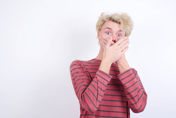 young man shocked covering mouth with hands for mistake. Secret concept. - Photo, Image