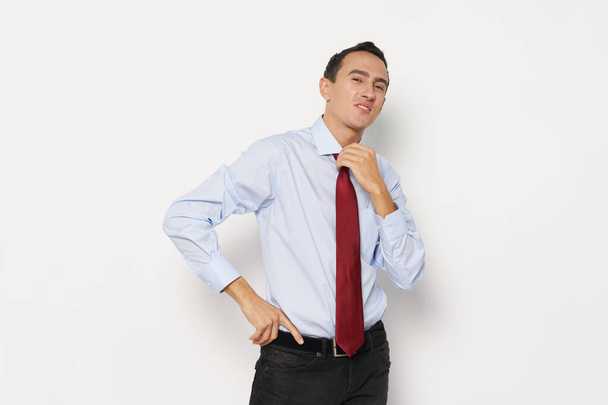 homem de negócios em uma camisa leve com um laço vermelho em torno de seu pescoço em um fundo leve - Foto, Imagem