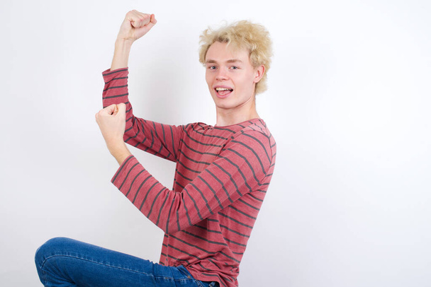 Profile photo of excited young blond man raising fists celebrating black Friday shopping - Photo, Image