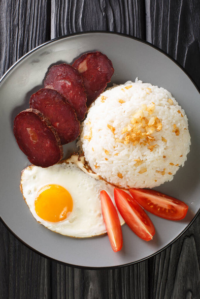 Чесночный рис подается с жареным яйцом и вяленым крупным планом в тарелке на столе. вертикальный вид сверху с борта - Фото, изображение