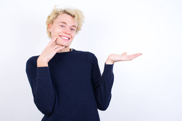 Funny young blond man hold open palm  - Foto, immagini
