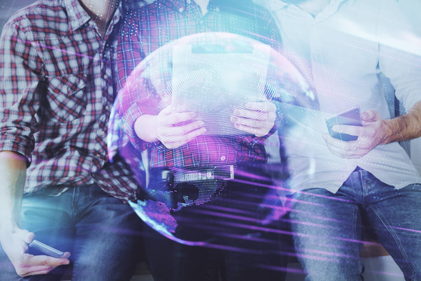Double exposure of tech theme hologram and man and woman working together holding and using a mobile device. - 写真・画像