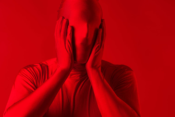 crazy screaming red man on a red background. figure in a leotard - Foto, Imagen