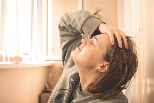 уставшая девушка фрилансер отдыхает на веранде после тяжелого и трудного дня на работе, держит лоб рукой с закрытыми глазами - Фото, изображение