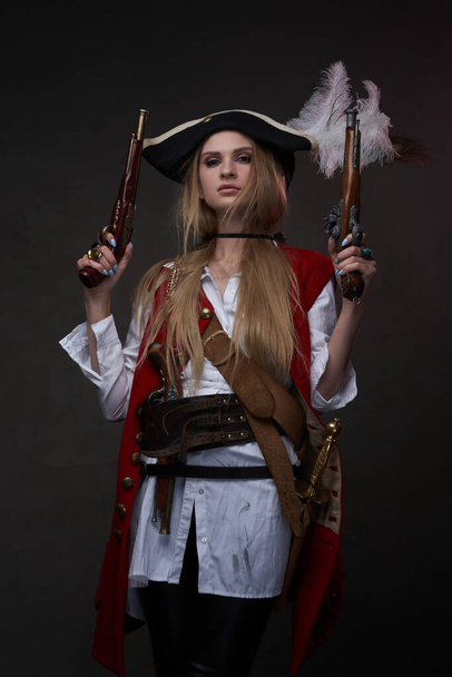 Женщина-бандит с трикорном в костюме и двумя пистолетами - Фото, изображение