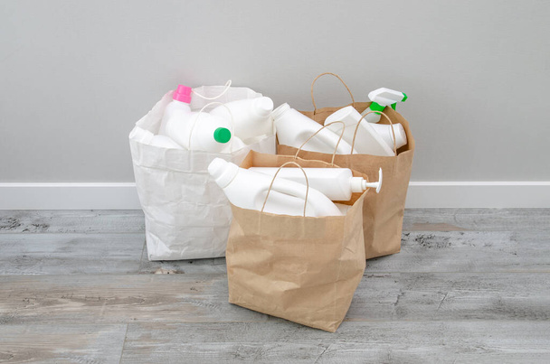 Household chemicals plastic bottles in a paper bag, recycling, and reuse concept - 写真・画像