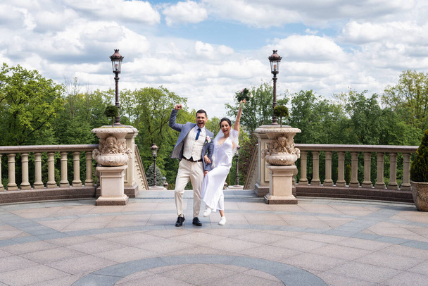Excited newlyweds showing yes gesture in park  - Foto, afbeelding