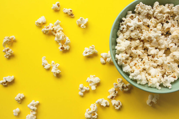 Lahodný popcorn v misce a na žlutém pozadí - Fotografie, Obrázek