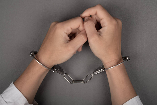 руки врача в наручниках крупным планом, арест хирурга - Фото, изображение