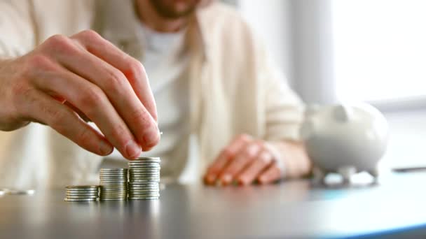 Blurry guy bank col blanc rassemble des pièces d'argent en piles - Séquence, vidéo