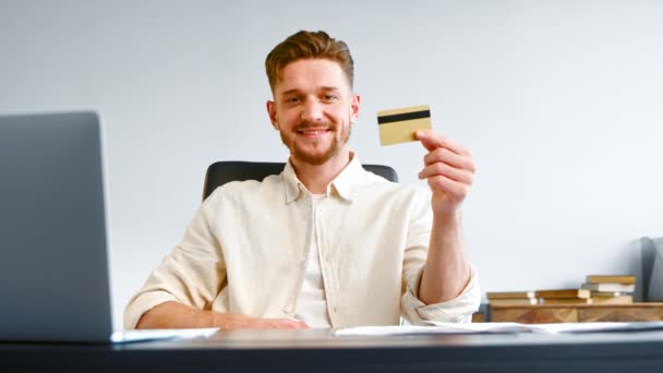 Seriózní muž firemní manažer s vousy drží bankovní kartu - Záběry, video