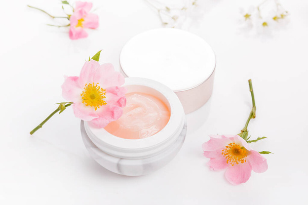 Wild rose dermatologia cosmética creme higiênico produto de cuidados da pele em frasco no fundo branco - Foto, Imagem
