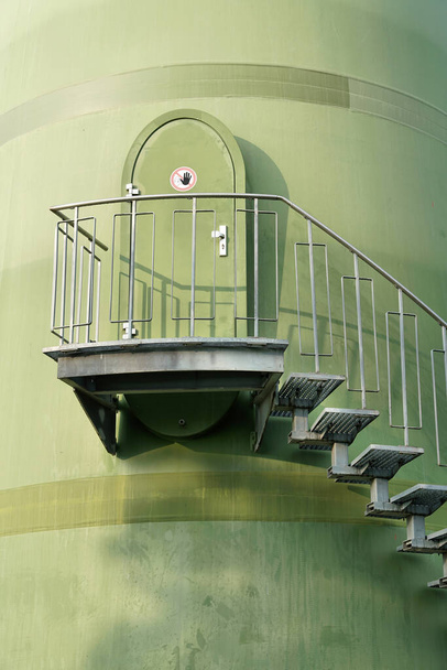   Escaleras de una puerta en la torre de un aerogenerador en una zona industrial de Magdeburgo en Alemania                              - Foto, Imagen