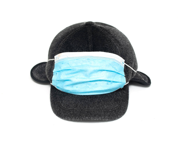 Mütze liegt auf weißem Hintergrund in einer Maske - Foto, Bild