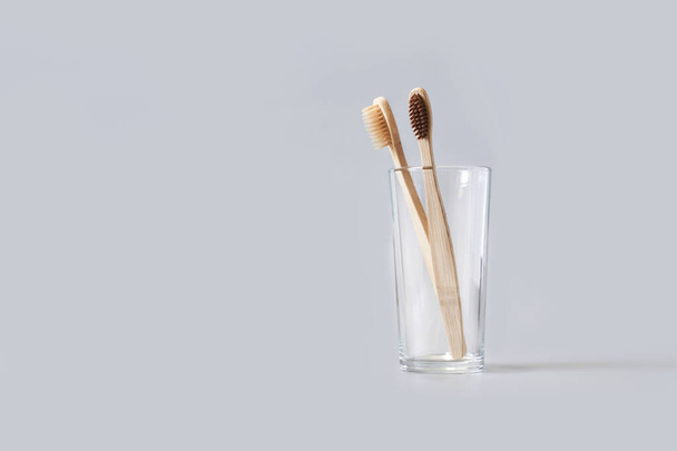 Ecology toothbrush on grey background. Brush in glass. Sustainable mouth product - Fotoğraf, Görsel