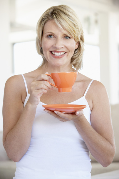 Mid Adult Woman Holding Tea Cup And Smiling At Camera - Fotografie, Obrázek
