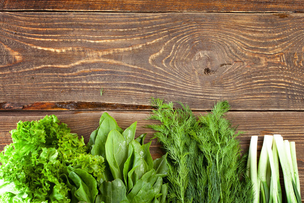 Fresh lettuce leaves, onions and fennel on a wooden background. top view. - Foto, Bild